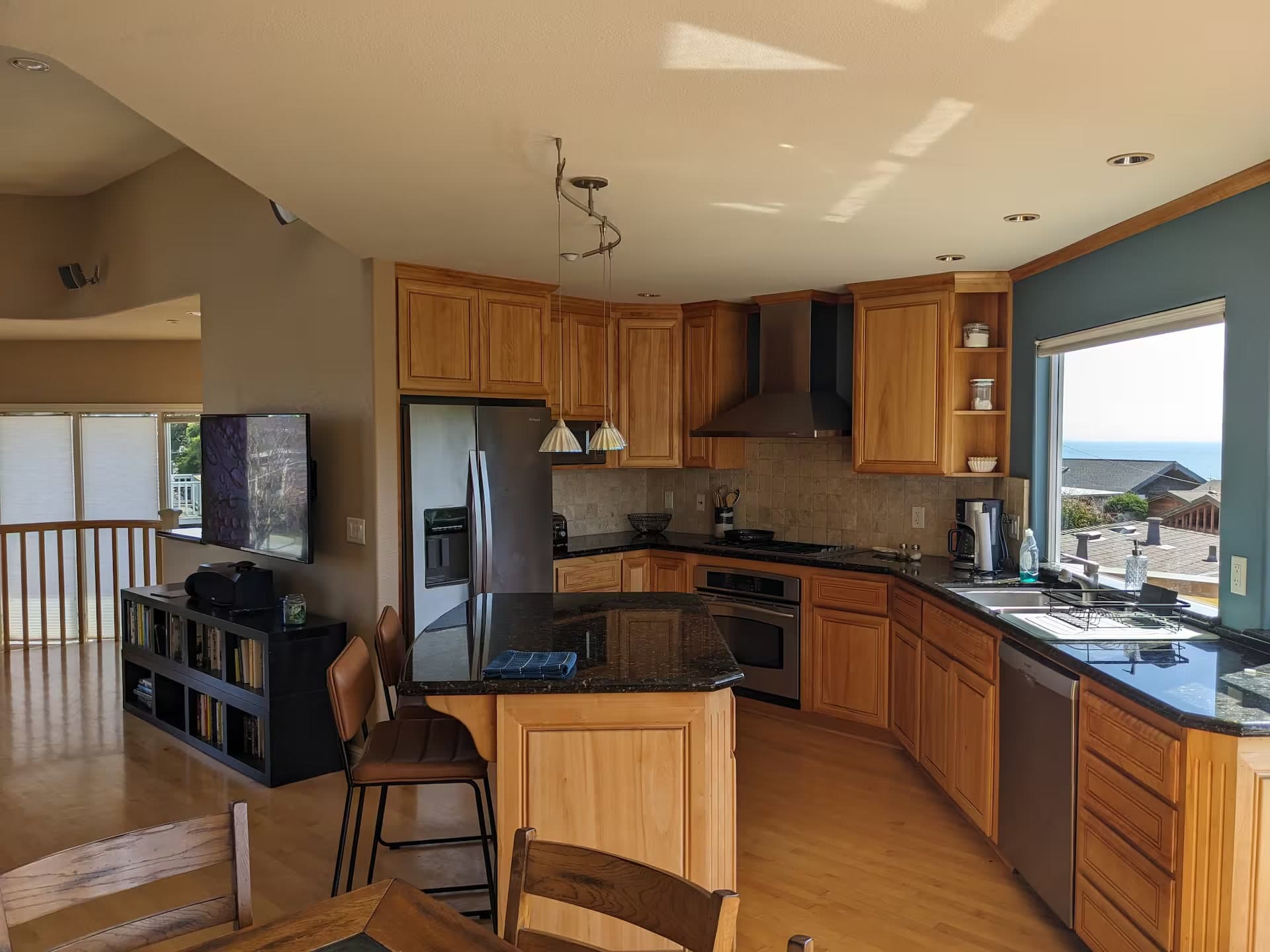 Kitchen with granite counters, stainless appliances, and an ocean view over the sink